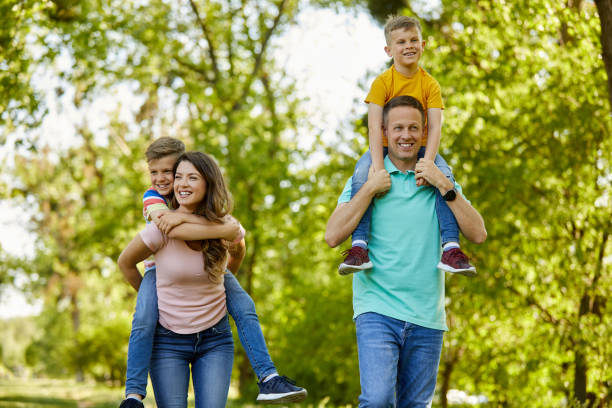 istock Parents piggybacking their sons in the park 1396481471