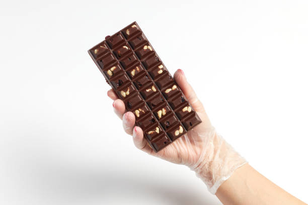 Appetizing bar of chocolate with nut filling in confectioner hand stock photo