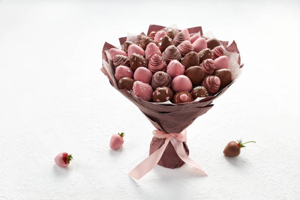 Sweet bouquet of strawberries covered with brown and pink chocolate on a white background stock photo