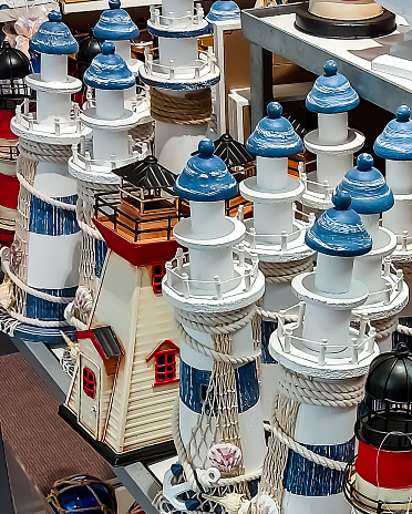 Blue and white stripe lighthouse model against white wall