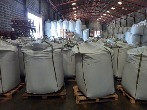 Large jumbo hemp sack White, packed with chemical fertilizer, rice, sugar, placed on a wooden pallet waiting to be delivered to the customer