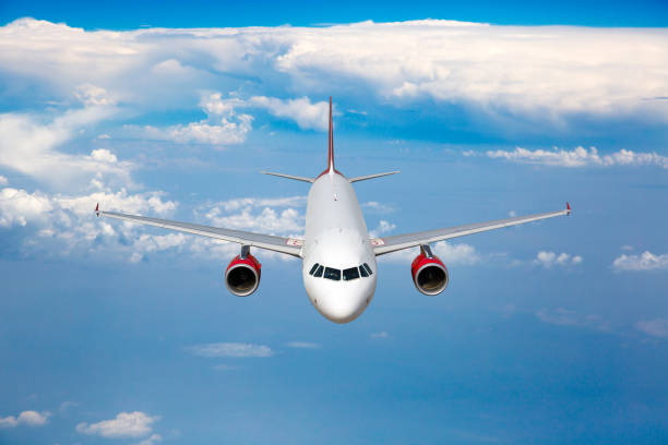 istock White passenger plane with red engines in flight. 1396490469