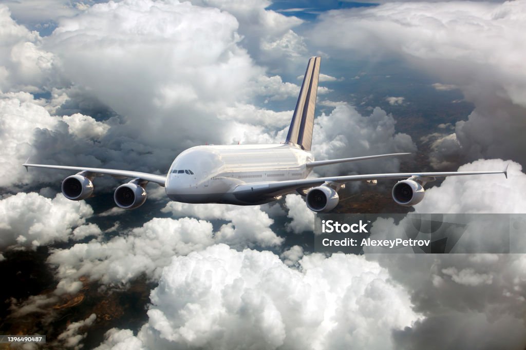 Passenger double decker plane fly high in the cloudy sky. Front view. Passenger double decker plane in flight. Aircraft fly high in the cloudy sky. Front view. Aerodynamic Stock Photo