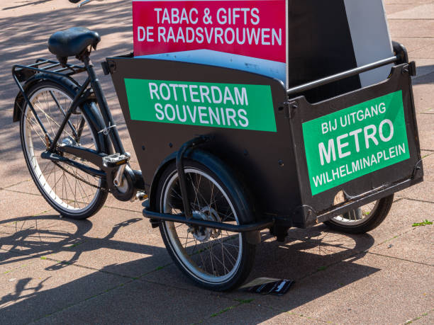 Rotterdam, Netherlands - April 28, 2022: Tricycle on the street with advertisement Billboard of Tobacco, Souvenirs and press store