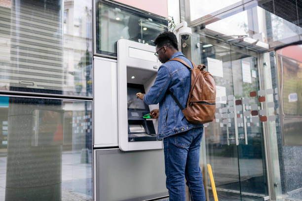 Young man retrieving money from his bank account stock photo