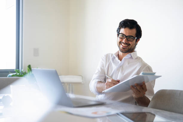 istock Young manager signing papers at his desk 1396495704
