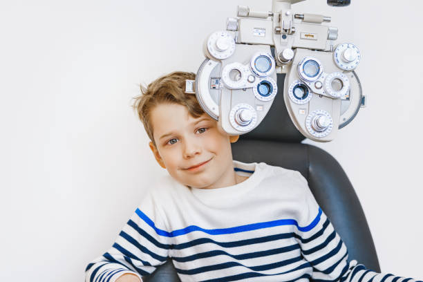 a school child doing eye test in clinic - patient happiness cheerful optometrist imagens e fotografias de stock