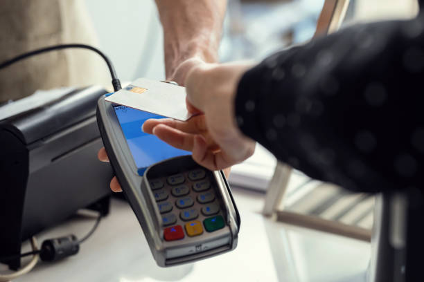 istock Customer using her credit card to make payment with electronic reader in the restaurant. 1396499588