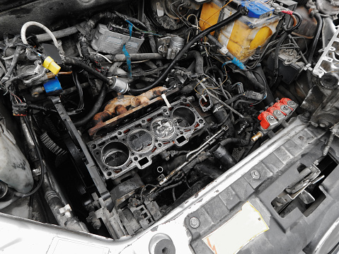 Disassembled engine under the hood of a car.