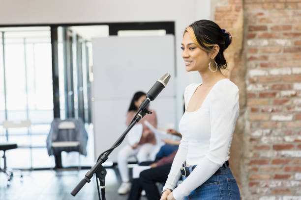 istock Young woman stands at the microphone 1396502642