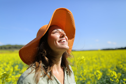 Happy woman laughing in a field a sunny day