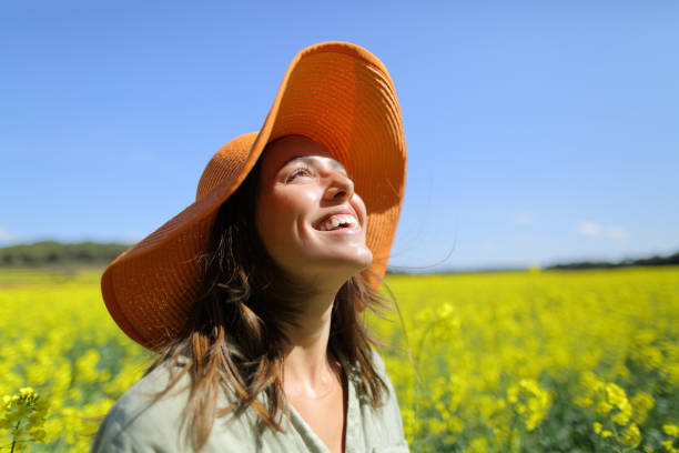 Happy woman laughing in a field a sunny day stock photo