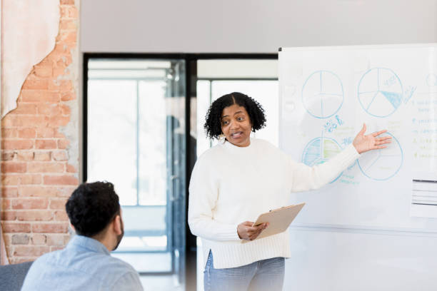 istock Female employee explains quarterly numbers to unrecognizable manager 1396502848