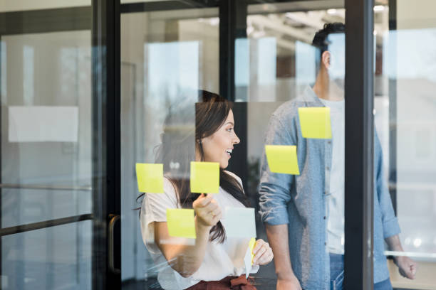 istock Two creatives look at unseen co-worker during brainstorming session 1396502957