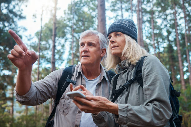 istock Shot of a mature couple using a cellphone while out on a hike together 1396504297