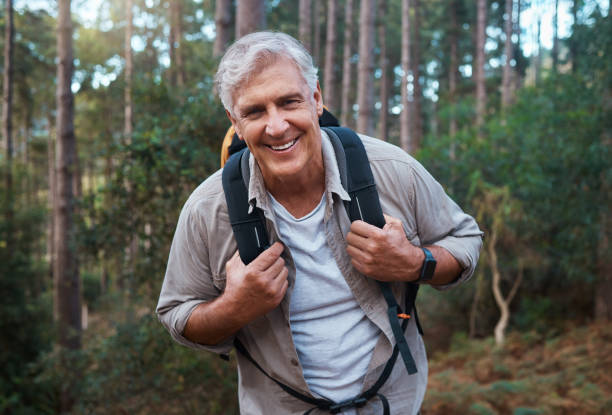 Shot of a mature man wearing his backpack while out hiking
