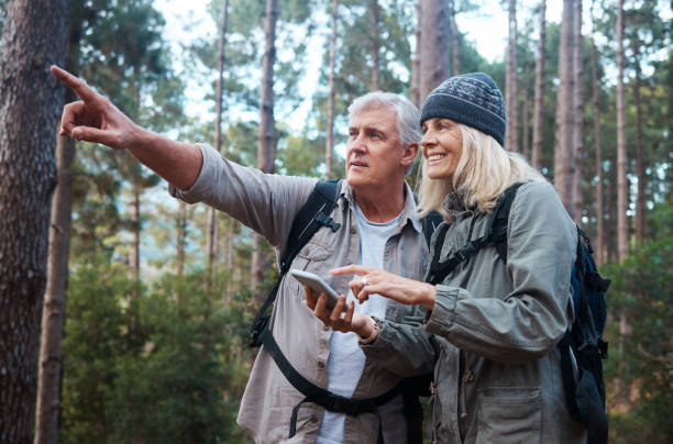 istock Shot of a mature couple using a cellphone while out on a hike together 1396504308