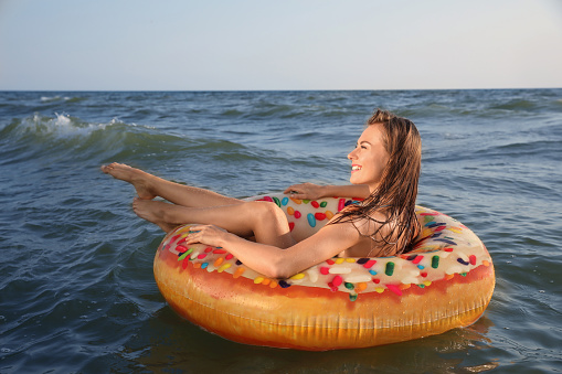 Happy woman with inflatable ring in sea