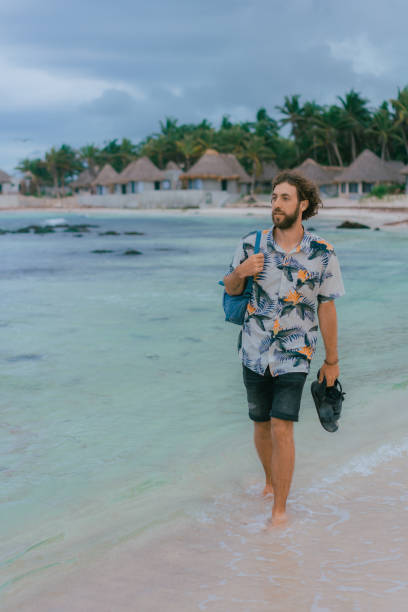 istock Man with backpack walking on the beach in Tulum 1396505195