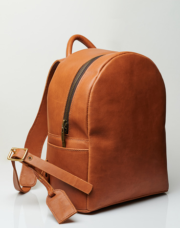 Casual brown leather bagpack isolated on studio background