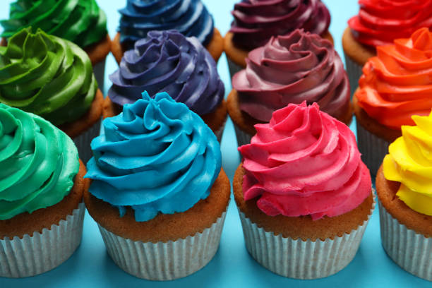 istock Many delicious colorful cupcakes on light blue background, closeup 1396506672