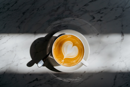 Café blanco plano con arte espumoso en la cafetería photo