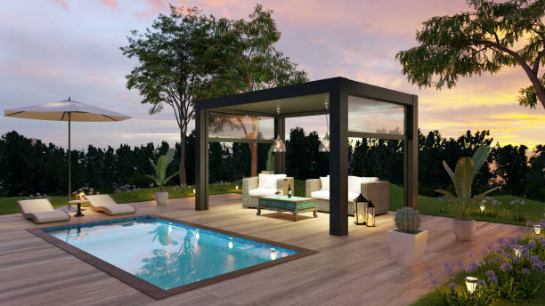 Karel Noppe 3D render of luxury side view outdoor garden with teak wooden deck and black pergola at dawn. Twilight scene with sofas and deck chairs next to the swimming pool. back yard stock pictures, royalty-free photos & images