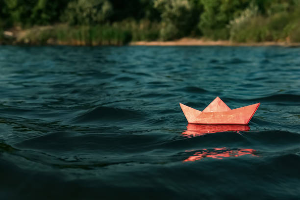istock Red paper boat floating on river, space for text 1396510058
