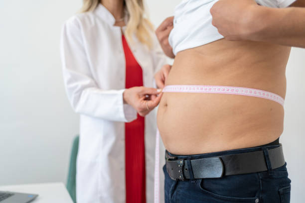 Waist Measurement Nutritionist Measuring Patient's Waist During Consultation In Office Bloating stock pictures, royalty-free photos & images