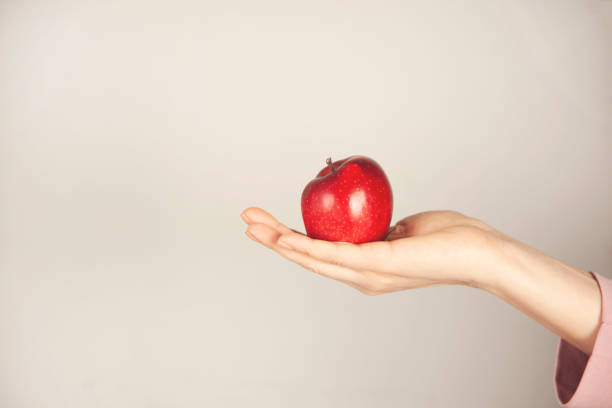 istock woman hand holding red apple 1396510784