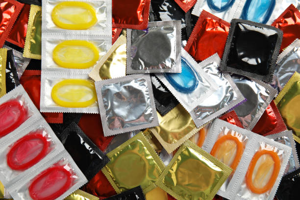 Pile of different condoms as background, top view Pile of different condoms as background, top view rubber stock pictures, royalty-free photos & images