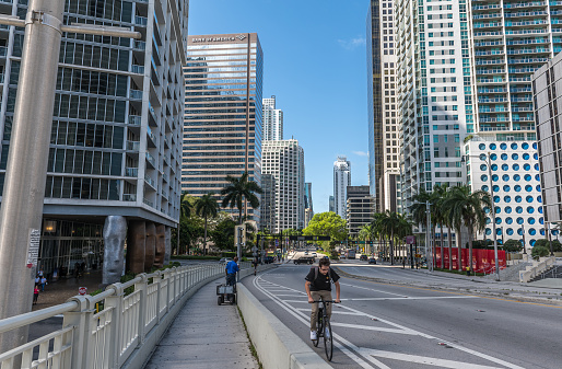 Miami, Florida - May 10, 2022: People traveling along Brickell Avenue, an area full of real estate developments and shopping centers. This is the main street that runs through the Brickell financial district of downtown Miami and is considered a desirable place associated with business and finance.