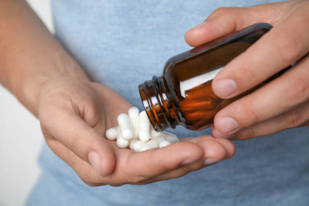 Man with amino acids pills on light background, closeup Man with amino acids pills on light background, closeup bodybuilding supplement stock pictures, royalty-free photos & images