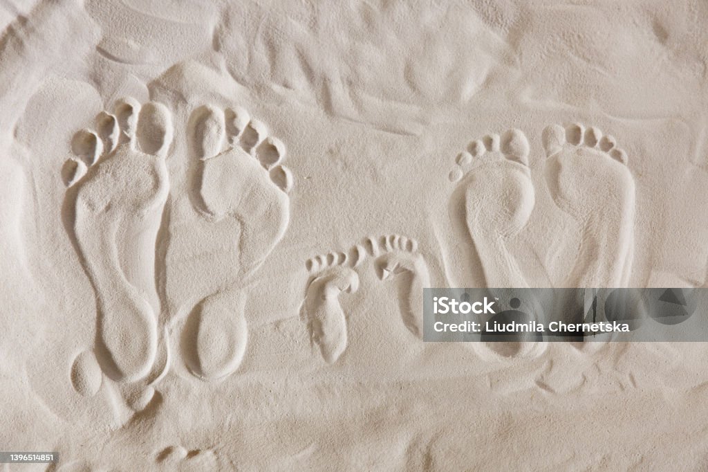 Family footprints on sandy beach, top view Footprint Stock Photo