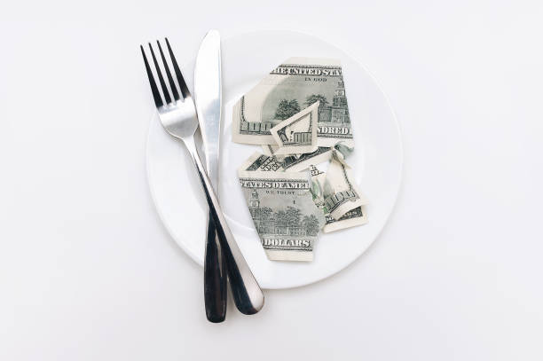 istock A torn hundred-dollar bill lies on a ceramic plate near a fork and a knife on a white tablecloth. The concept of business lunch, banking, life rentier and financial well-being. 1396516887