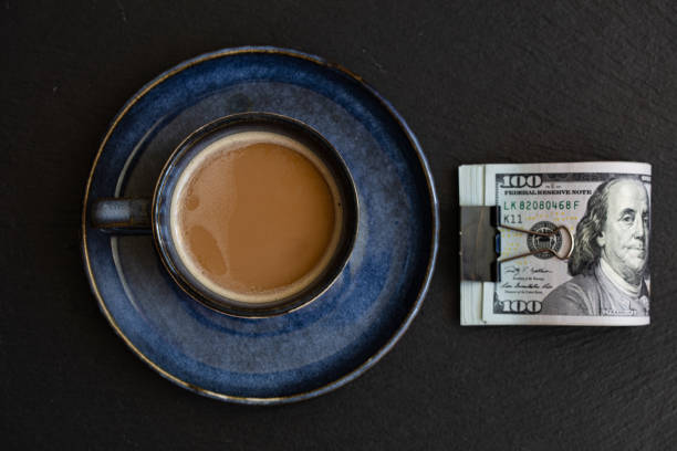 istock cup of coffee on 100 dollar banknotes background 1396517964
