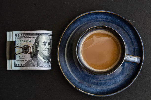 istock cup of coffee on 100 dollar banknotes background 1396518080