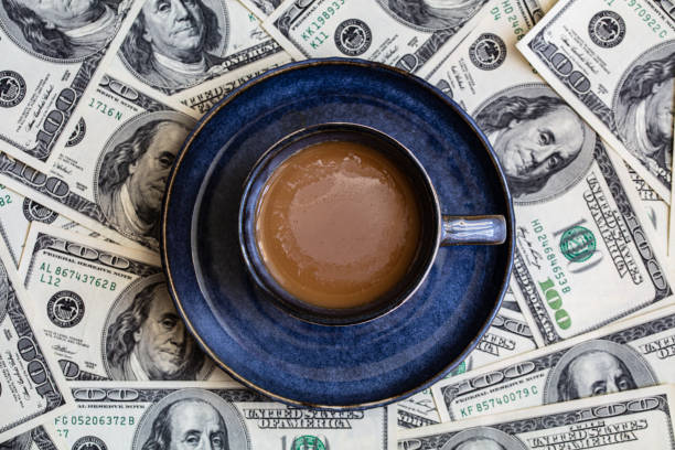 istock cup of coffee on 100 dollar banknotes background 1396518186