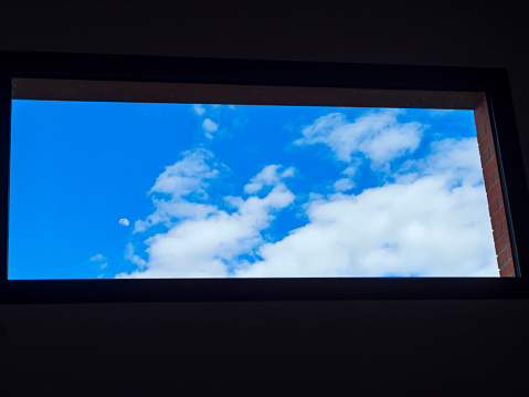 Blue sky with clouds through a window