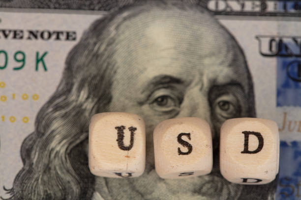 istock USD word written on wooden blocks on 100 dollar banknote background 1396519250