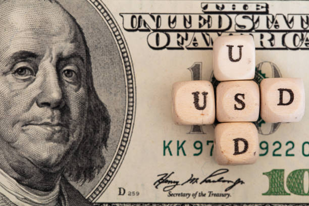 istock USD word written on wooden blocks on 100 dollar banknote background 1396519432