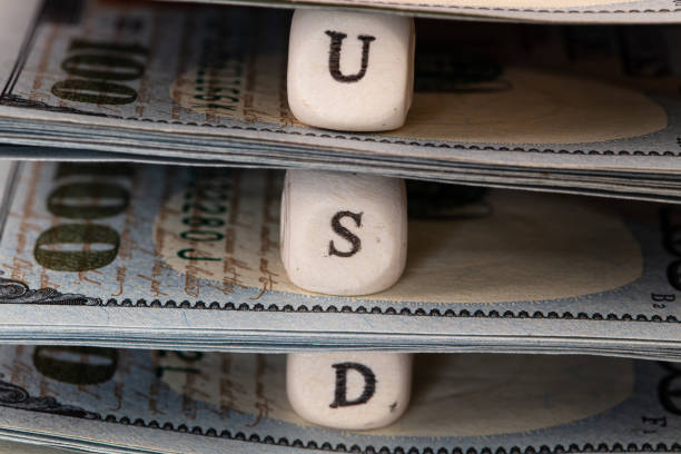 istock USD word written on wooden blocks on 100 dollar banknote background 1396519524