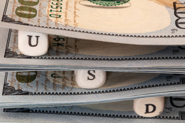 istock USD word written on wooden blocks on 100 dollar banknote background 1396519555
