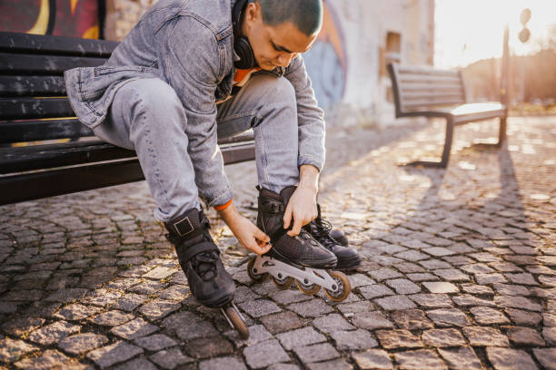 istock Man putting on roller skates. Changing casual shoes to roller skates before ride and training during summer leisure and recreation 1396522604
