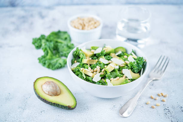 istock Kale avocado pine nuts cheese salad with lemon dressing in a bowl 1396525000