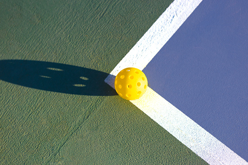 Pickleball and Shadow on Sunny Sports Court Close-Up