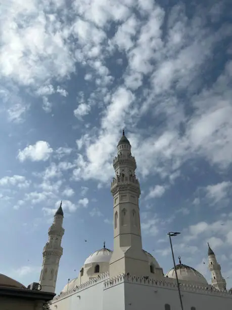 The dome, towers and minarets of Masjid Quba with pigeons on the roof