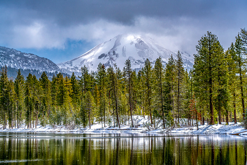 Lassen Peak and Reflection Lake with reflections from pines along the shore.