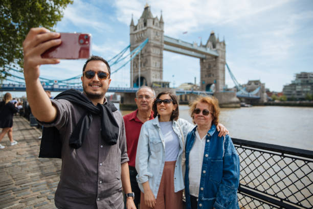 young family taking vacation selfie photo in london as tourists - tower bridge fotos imagens e fotografias de stock