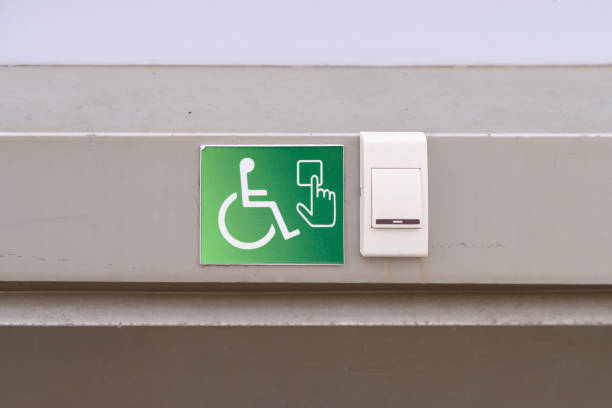 A staff call button for people with reduced mobility on a green sign